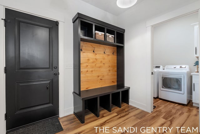 mudroom with independent washer and dryer and light hardwood / wood-style flooring