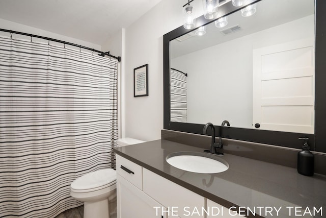 bathroom featuring vanity, toilet, and curtained shower