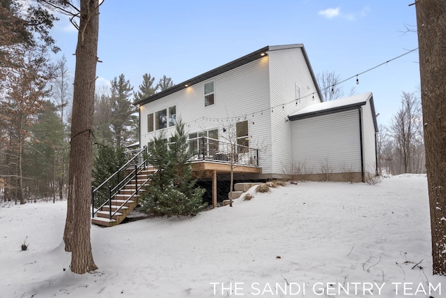 snow covered property with a deck