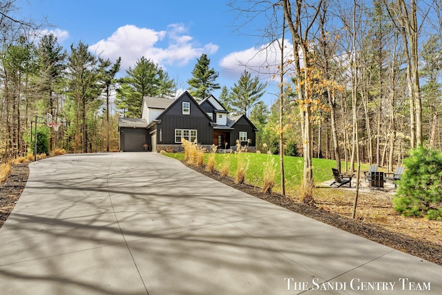 16500 Haven Woods Ct, West Olive, MI 49460 - view of front of house featuring concrete driveway, board and batten siding, an attached garage, and a front yard