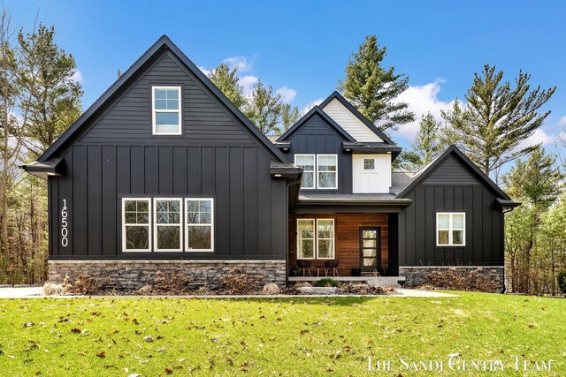 16500 Haven Woods Ct, West Olive, MI 49460 - modern farmhouse style home featuring board and batten siding, a front yard, covered porch, and stone siding