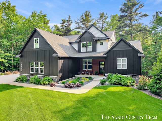 16500 Haven Woods Ct, West Olive, MI 49460 - view of front of house featuring board and batten siding, a front lawn, a porch, and roof with shingles