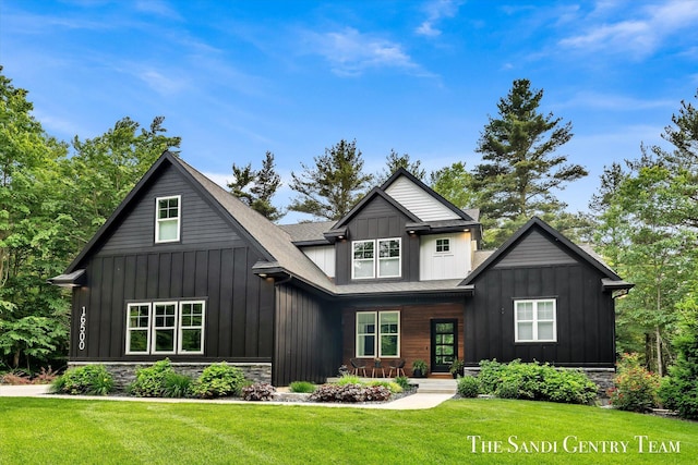 16500 Haven Woods Ct, West Olive, MI 49460 - view of front of home with board and batten siding, a front lawn, and a porch