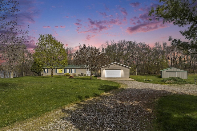 view of front facade with an outdoor structure, a garage, and a yard