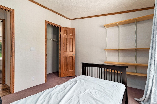 bedroom with a textured ceiling, dark carpet, a closet, and crown molding