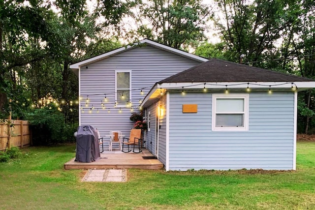 rear view of property featuring a lawn and a wooden deck