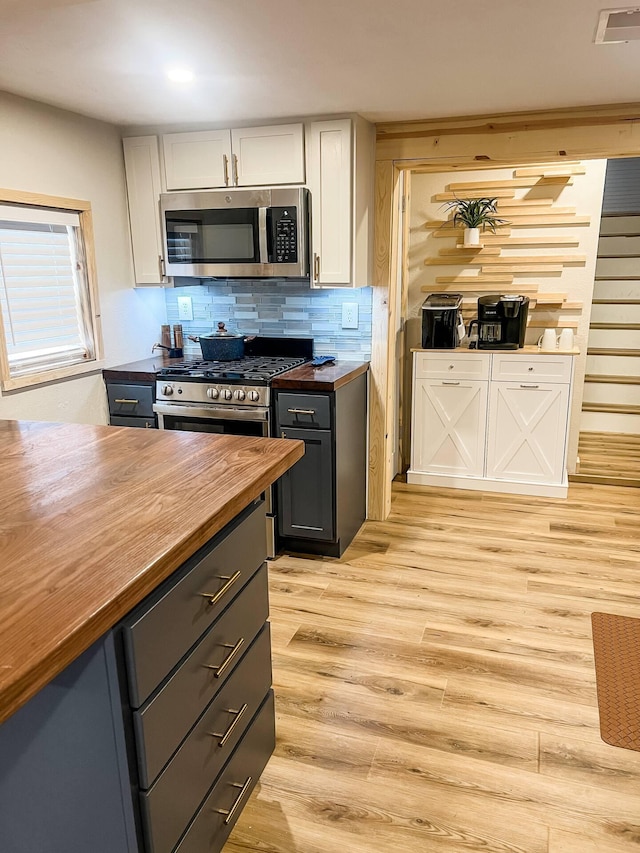 kitchen featuring butcher block countertops, gray cabinets, decorative backsplash, and white cabinets