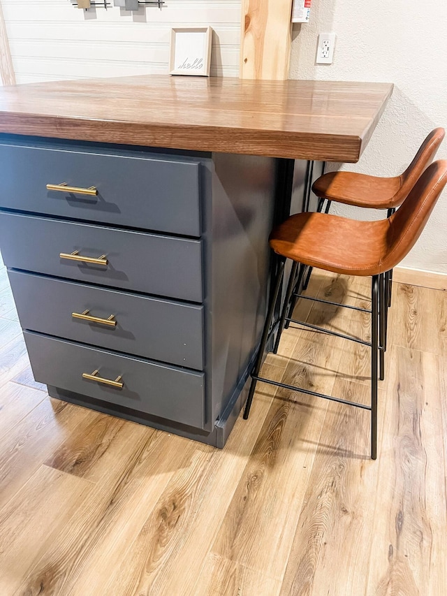 bar with light hardwood / wood-style floors and butcher block counters