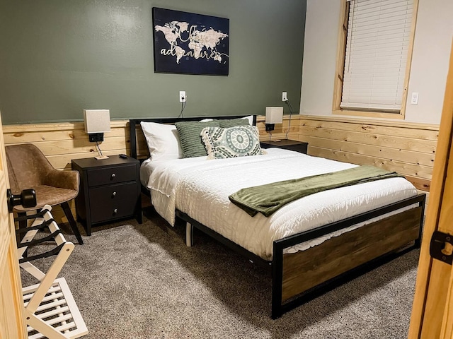 carpeted bedroom with wood walls