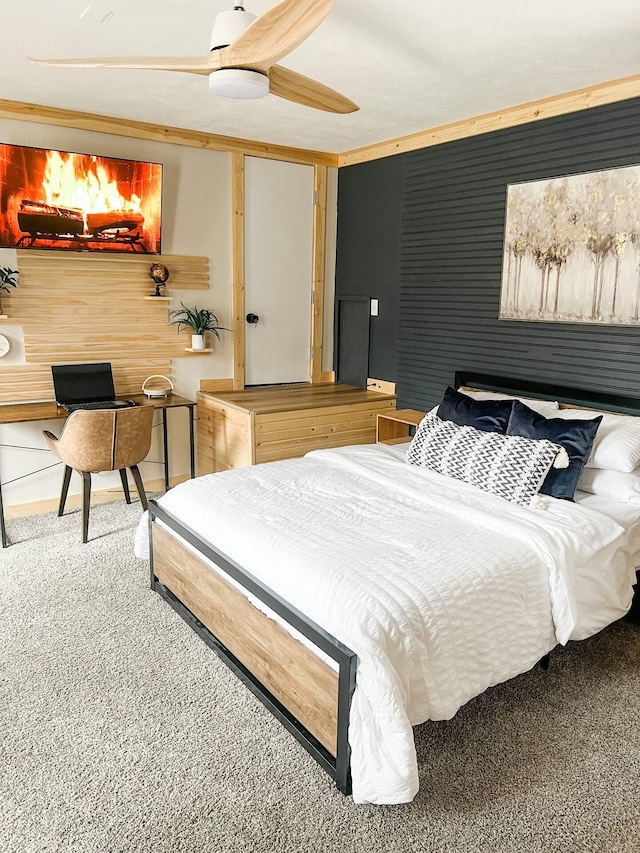 carpeted bedroom featuring ceiling fan and crown molding