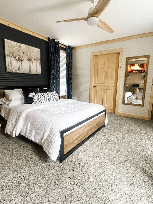 carpeted bedroom featuring ceiling fan and ornamental molding