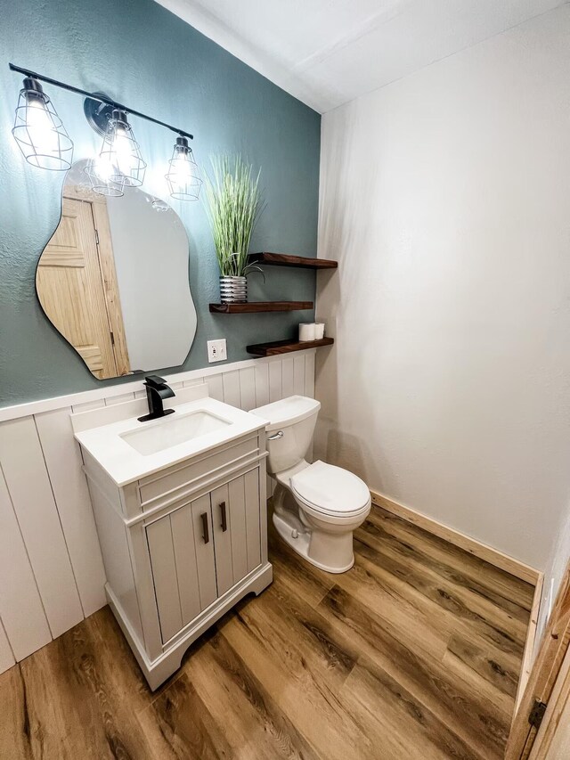 bathroom featuring vanity, wood-type flooring, and toilet