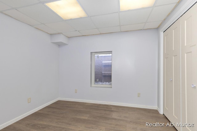 spare room featuring a paneled ceiling and wood-type flooring