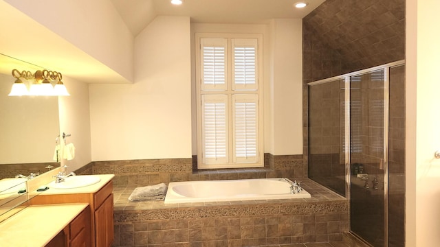 bathroom featuring vanity, independent shower and bath, and vaulted ceiling