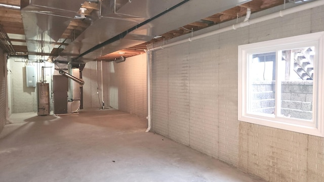 basement featuring electric panel, water heater, and heating unit