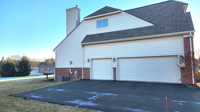 view of side of home with central AC and a garage