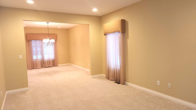 unfurnished room featuring carpet flooring and a notable chandelier