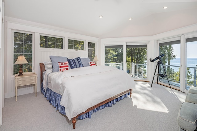 carpeted bedroom with access to exterior, a water view, and lofted ceiling