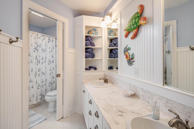 bathroom with tile patterned flooring, vanity, toilet, and walk in shower