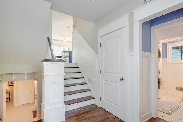 staircase with hardwood / wood-style floors and stacked washer / drying machine