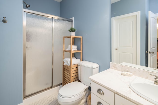 bathroom featuring vanity, a shower with shower door, and toilet