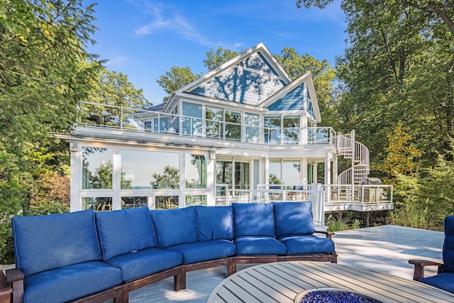 back of house featuring a deck, an outdoor living space, a balcony, and stairs