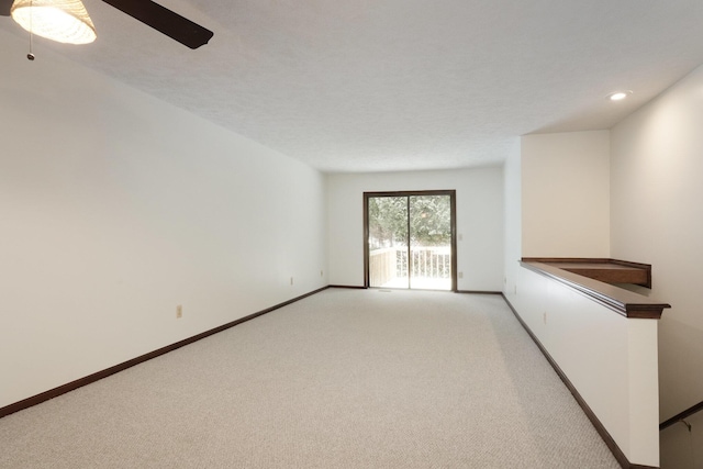 unfurnished room with ceiling fan and light colored carpet