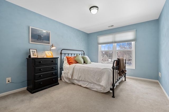 bedroom featuring baseboards, visible vents, and light colored carpet