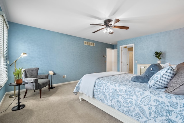 bedroom featuring light colored carpet, a ceiling fan, baseboards, visible vents, and wallpapered walls
