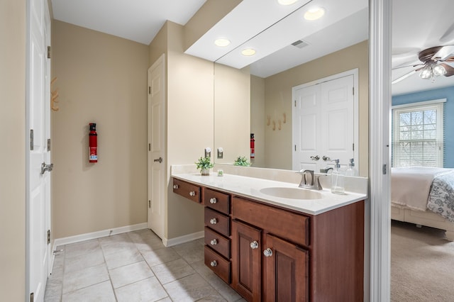 bathroom featuring ensuite bathroom, ceiling fan, vanity, baseboards, and tile patterned floors