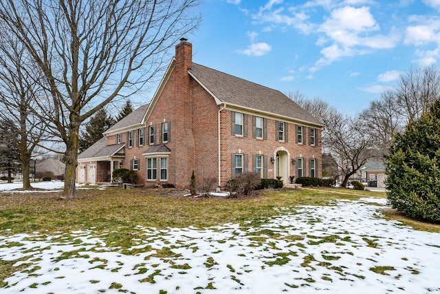 view of front of home featuring brick siding, a yard, and a chimney