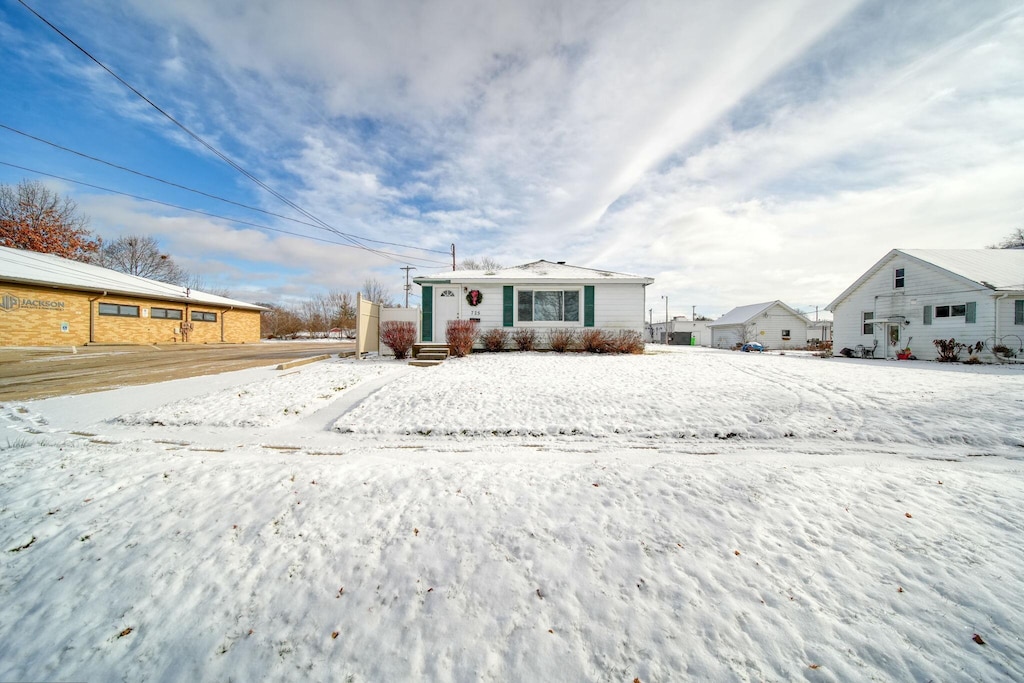 view of snow covered back of property