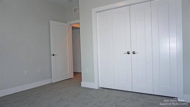 unfurnished bedroom featuring a closet and light colored carpet