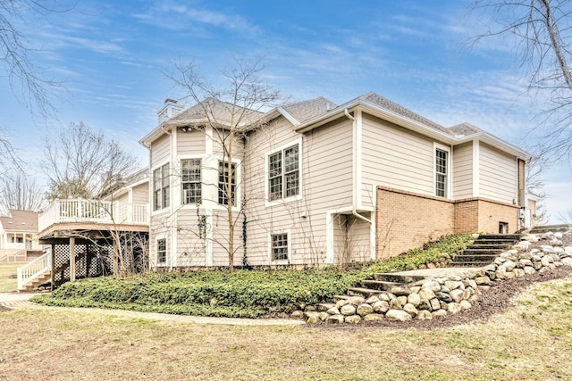 view of side of property with a lawn and a wooden deck