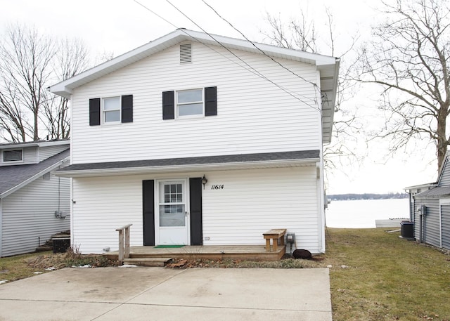 view of front facade with a front lawn, cooling unit, and a patio