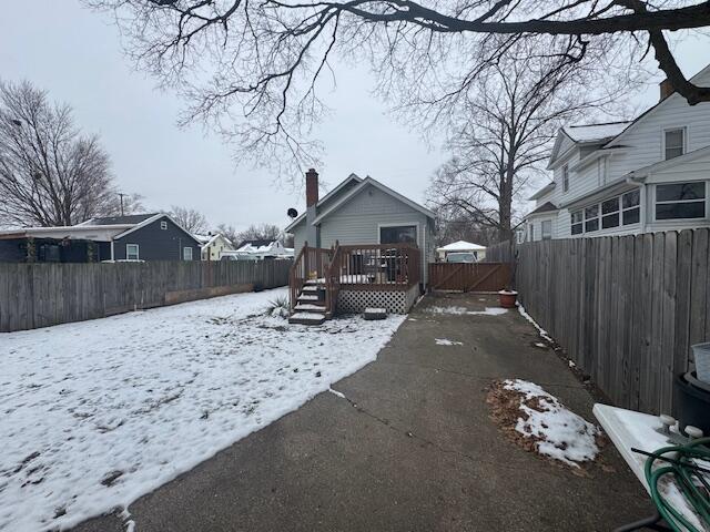 yard covered in snow with a deck