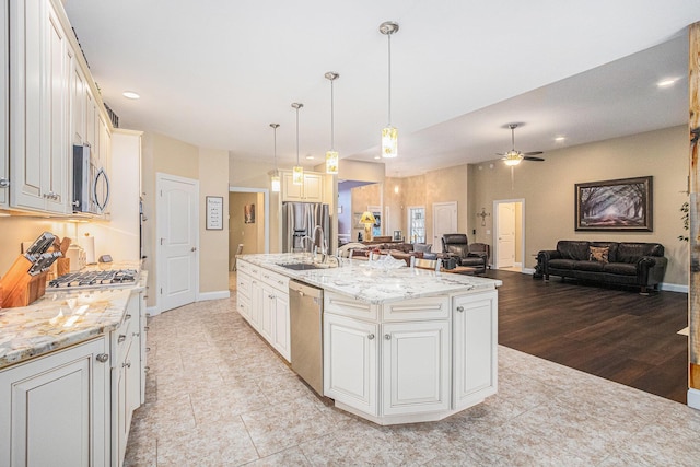 kitchen with ceiling fan, sink, an island with sink, decorative light fixtures, and appliances with stainless steel finishes