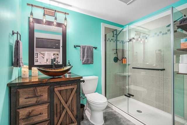 bathroom featuring vanity, toilet, and a shower with shower door