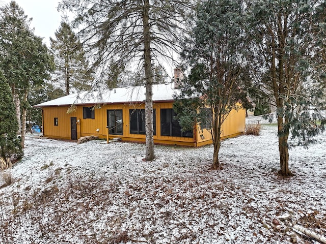 view of snow covered back of property