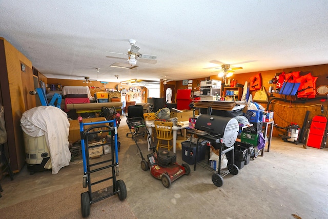 misc room with a textured ceiling, concrete flooring, and ceiling fan