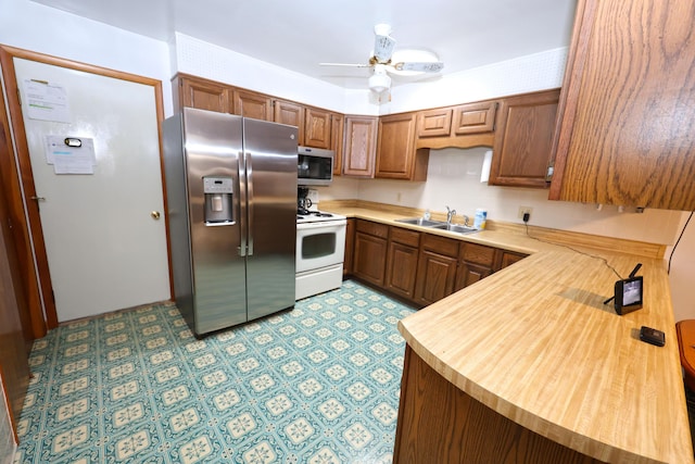 kitchen featuring kitchen peninsula, sink, ceiling fan, and stainless steel appliances