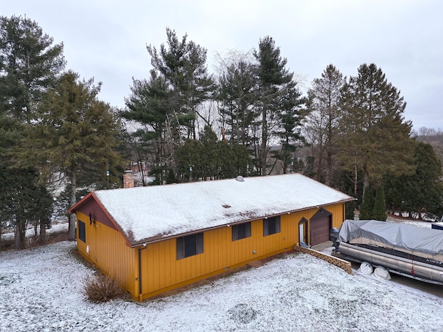 view of snow covered exterior featuring an outdoor structure and a garage