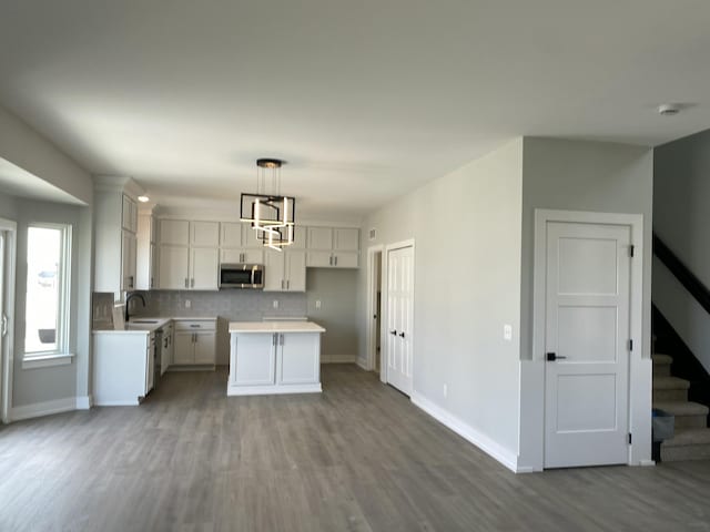 kitchen featuring white cabinets, pendant lighting, a center island, and decorative backsplash