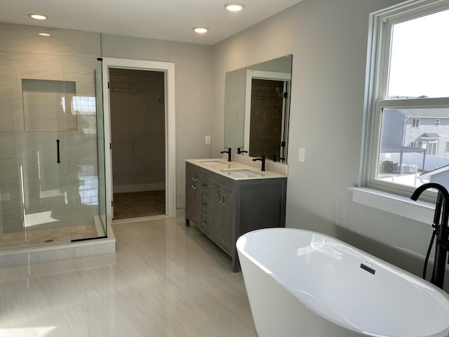 bathroom featuring plus walk in shower, vanity, and tile patterned flooring