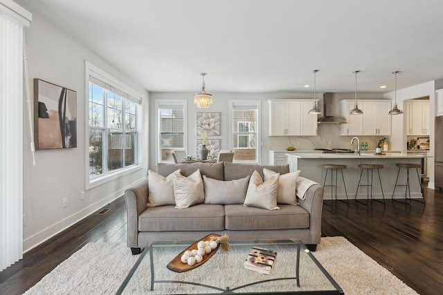 living room with dark hardwood / wood-style flooring and sink