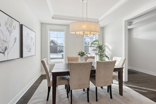 dining room with a chandelier, dark hardwood / wood-style floors, and a raised ceiling