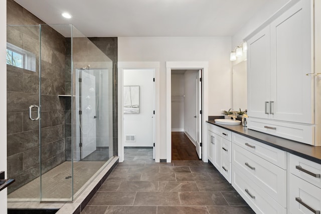 bathroom featuring walk in shower and vanity