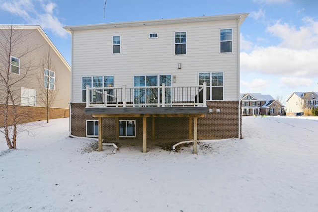 snow covered house featuring a wooden deck