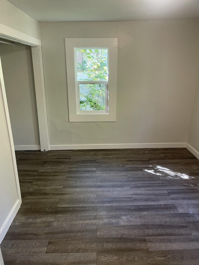 unfurnished room with dark hardwood / wood-style flooring