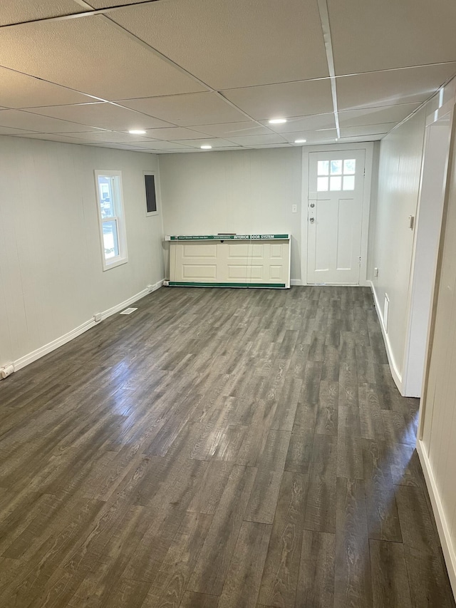 basement with a drop ceiling and dark wood-type flooring